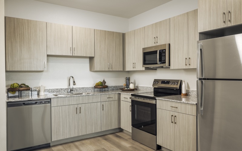 a light colored kitchen with stainless steel appliances