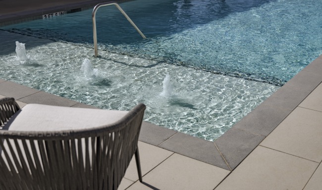 a sparkling pool with bubblers and a chair on the side